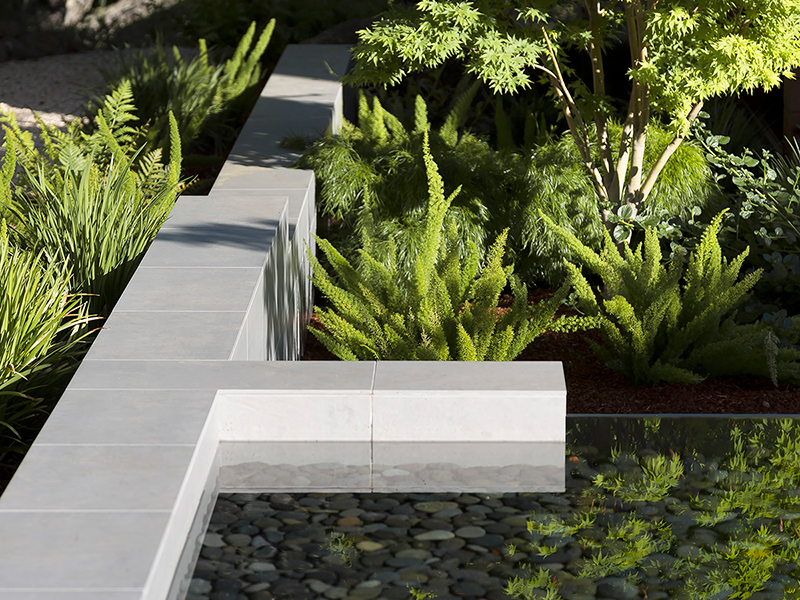 a cascading water feature in a drought tolerant garden