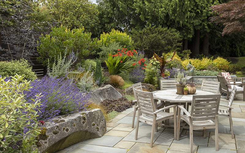 outdoor dining room with colorful garden around it