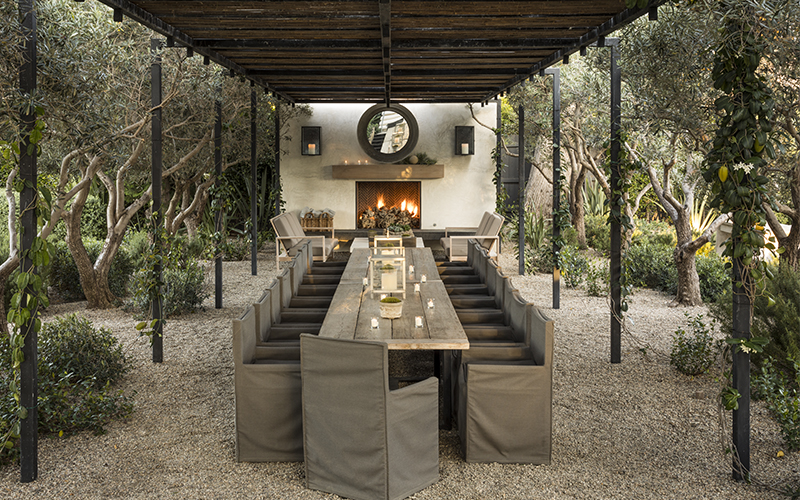 long dining room table in front of outdoor fireplace