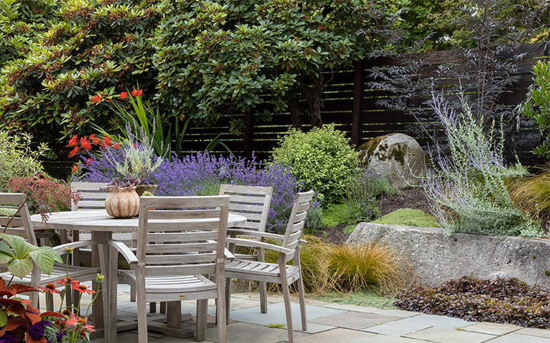 outdoor dining room with colorful garden around it